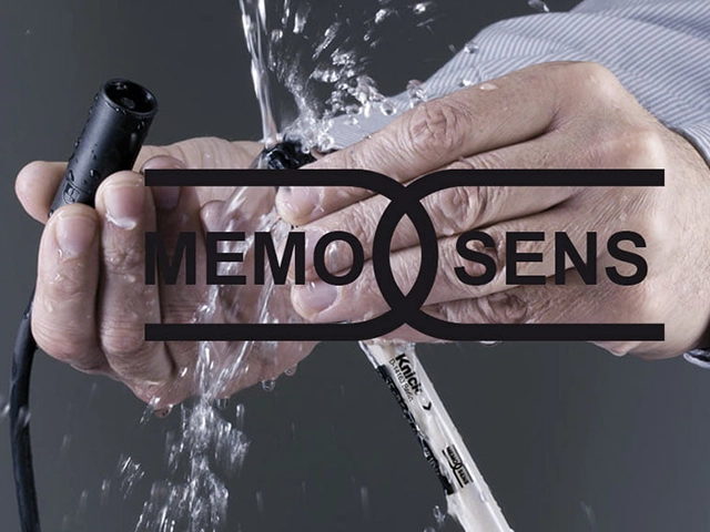Ein Memosens-Sensor und Kabel von Knick werden mit den Händen unter fließendes Wasser gehalten